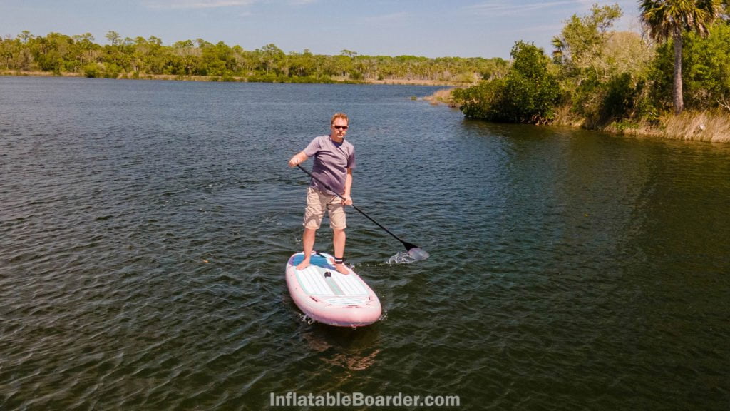 A man paddling the board on a river.