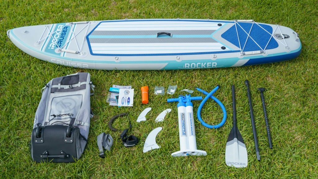 Overview of the 2021 iROCKER Cruiser accessories bundle, includes color-matched bag, color-matched SUP leash, color-matched paddle, premium pump, 3 fins, repair kit, compression strap, warranty card, manual, and sticker pack.