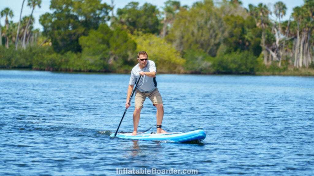 Paddling the board on a calm bay.