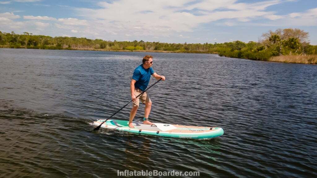 A man paddling fast on a lake.