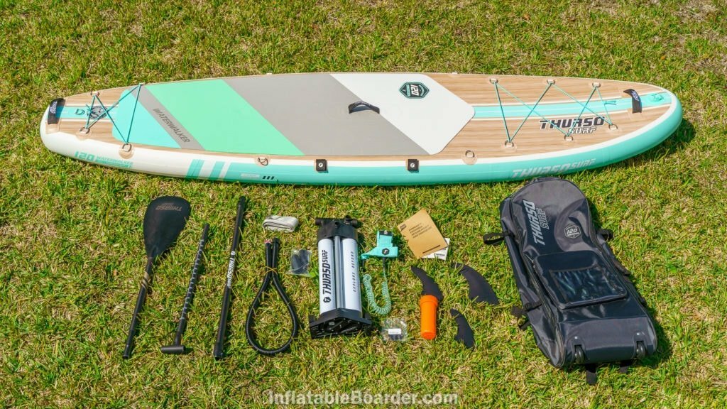 Aqua-colored Thurso Waterwalker 120 with accessories, including bag, 3 fins, pump, paddle, leash, repair kit, manual, and compression strap.