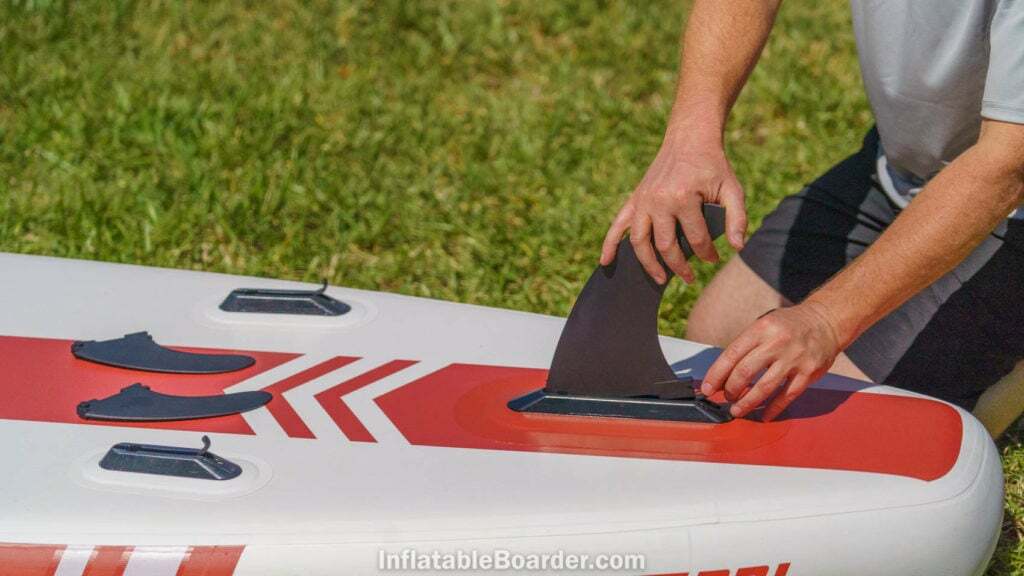 Attaching the three quick-connect fins on the bottom of the board.