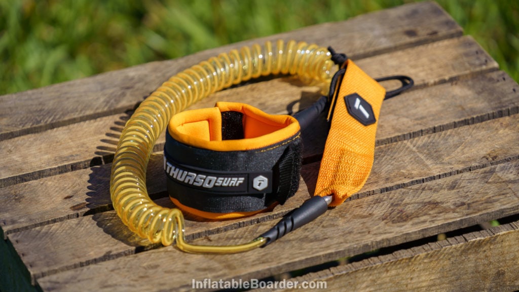 The coiled SUP leash is color matched to the board's theme.