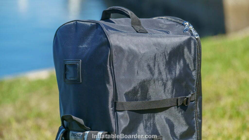 The top of the bag has a padded handle, compression straps, and luggage tag.