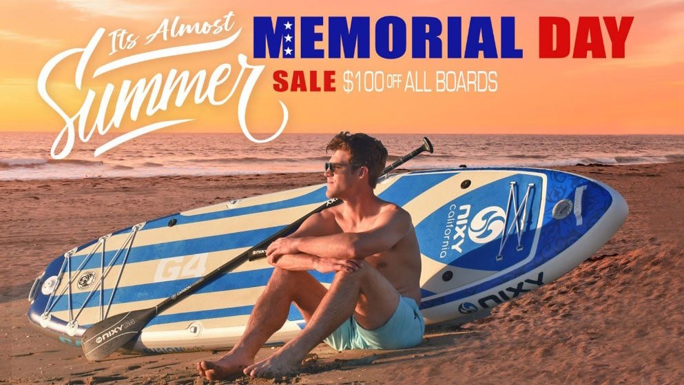 Man on beach with NIXY G4 board. Text reads: Memorial Day Sale - $100 off all boards