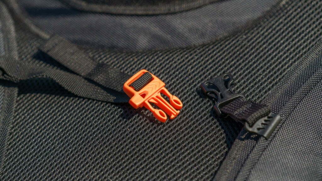 The orange chest strap clip has an integrated emergency whistle.