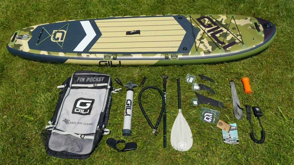 Unboxed GILI Air 10'6 accessories, including basic bag, compact pump, aluminum paddle, 3 fins, SUP leash, repair kit, compression strip, and documentation.