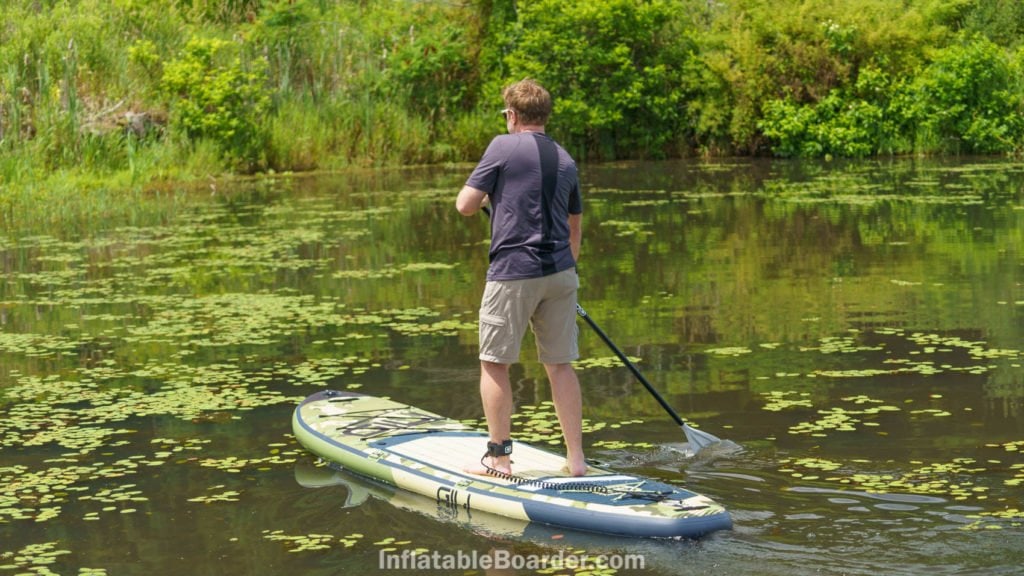 Paddling the board on a smooth pond.