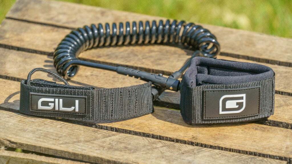 The SUP leash is coiled and black in color.