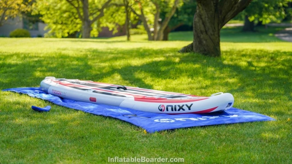 NIXY SUP landing mat rolled out with board and fins.